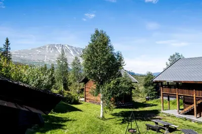a log cabin with a mountain in the background at Kvitåvatn Fjellstue in Gaustablikk