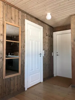 an empty room with a door and a mirror at Drolsum Gård in Vikersund