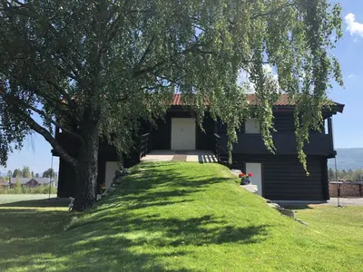 a house with a tree in front of it at Drolsum Gård in Vikersund