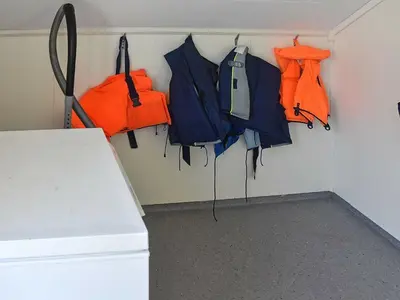 a room with coats and umbrellas hanging on a wall at 6 person holiday home in Onarheim in Onarheim