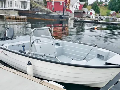 a white boat docked at a dock in the water at 6 person holiday home in Onarheim in Onarheim