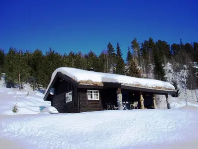 a log cabin with snow on top of it at Hogstul Hytter - Skojestua - 2 Bedroom Cottage in Tuddal