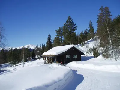 a snow covered cabin on a snow covered mountain at Hogstul Hytter - Skojestua - 2 Bedroom Cottage in Tuddal