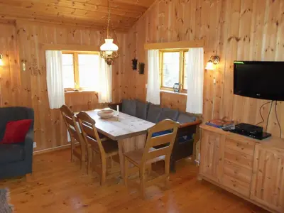 a dining room with a table and chairs and a television at Hogstul Hytter - Skojestua - 2 Bedroom Cottage in Tuddal