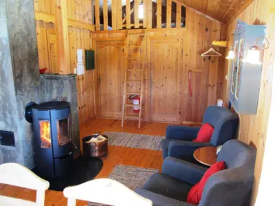 a living room with a fireplace and a couch and a stove at Hogstul Hytter - Skojestua - 2 Bedroom Cottage in Tuddal