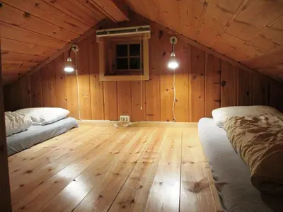 a room with two beds and a wooden floor at Hogstul Hytter - Skojestua - 2 Bedroom Cottage in Tuddal