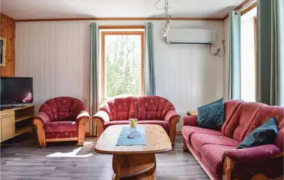 a living room with red couches and a coffee table at 4 Bedroom Beautiful Home In Steinstø in Steinstø