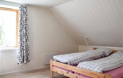 two beds in a attic bedroom with a window at 4 Bedroom Beautiful Home In Steinstø in Steinstø