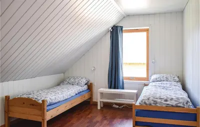 two beds in a room with a window at 4 Bedroom Beautiful Home In Steinstø in Steinstø