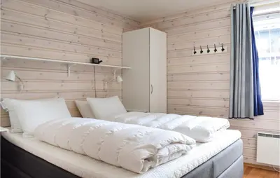 a large white bed in a room with wooden walls at Fjellstua C3, Leil 202 in Sjusjøen