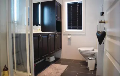 a bathroom with a toilet and a glass shower at Three-Bedroom Holiday Home In Hovet in Hovet