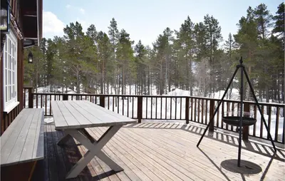 a wooden deck with a wooden table and a bench at Three-Bedroom Holiday Home In Hovet in Hovet
