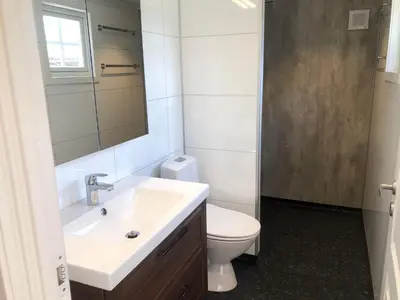 a bathroom with a sink and a toilet and a mirror at Vågåvatnet Feriesenter in Vågåmo