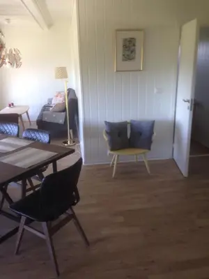a living room with a table and chairs and a bed at Malenes Ferieleiligheter in Rauland