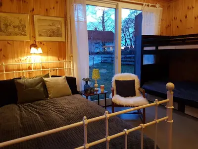 a bedroom with a bed and a large window at Drengestua på Flagstad Østre in Hamar