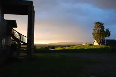 a view of a house and a tree at sunset at Drengestua på Flagstad Østre in Hamar
