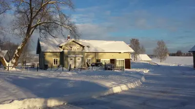 an old house in the snow with a tree at Drengestua på Flagstad Østre in Hamar