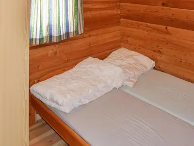 a small bed in a wood paneled room at 8 person holiday home in olden in Olden