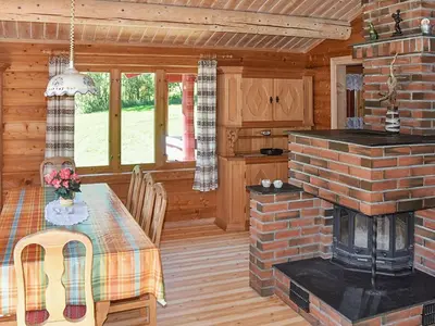 a kitchen and dining room with a table and a fireplace at 8 person holiday home in olden in Olden