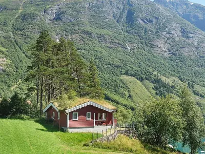 a small red house on a hill with a mountain at 8 person holiday home in olden in Olden