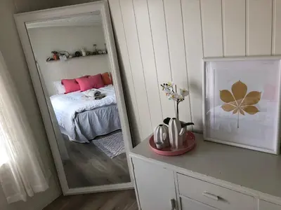 a mirror in a room with a bed and a bedroom at Olsens Pensjonat in Veiholmen