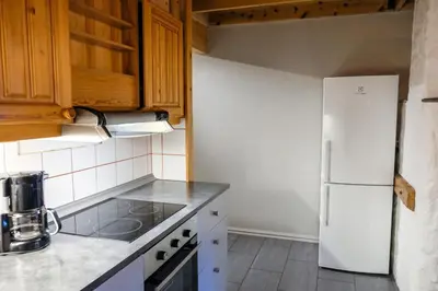 a kitchen with a white refrigerator and wooden cabinets at Hemsetunet Apartments in Hemsedal