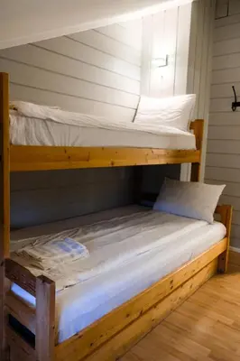 two bunk beds in a room with white sheets at Hemsetunet Apartments in Hemsedal