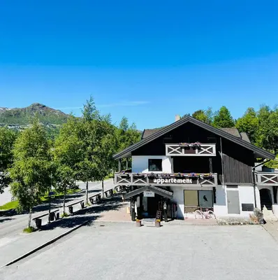 a large black and white building with a parking lot at Hemsetunet Apartments in Hemsedal
