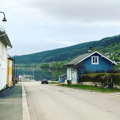 a street with a blue building on the side of a road at Charming Lakeside House with sauna in Lillehammer