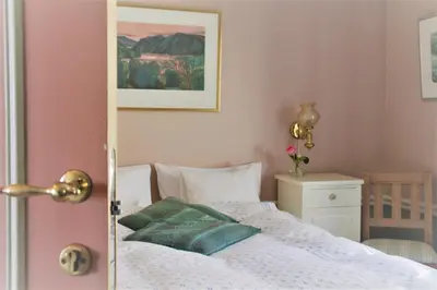 a bedroom with a bed and a picture on the wall at Nutheim Gjestgiveri in Flatdal