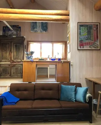 a living room with a brown couch and a table at Nutheim Gjestgiveri in Flatdal