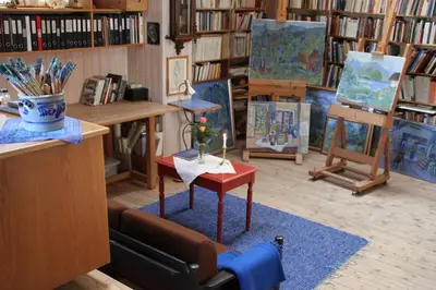 a room with paintings and a couch and a table at Nutheim Gjestgiveri in Flatdal