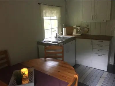 a kitchen with a table and a sink and a wooden table at Briksdalsbre Fjellstove in Briksdalsbre
