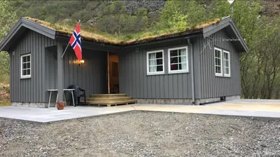 a small house with a flag in front of it at Briksdalsbre Fjellstove in Briksdalsbre