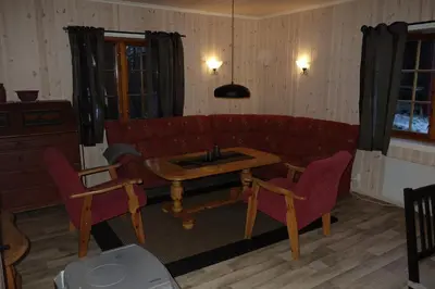 a living room with a red couch and a table at Roste Hyttetun og Camping in Os