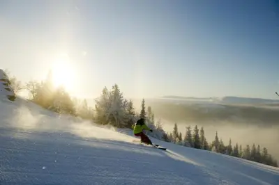 a person is skiing down a snow covered slope at Lille Randklev Gæstehus in Ringebu