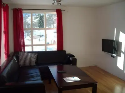 a living room with a couch and a table and a window at Røldal Overnatting in Røldal