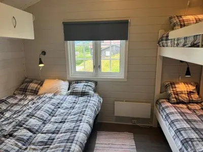 two beds in a small room with a window at Sørlia hytte in Hafjell