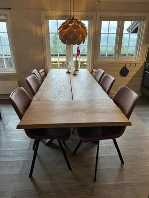 a large wooden table in a room with chairs at Sørlia hytte in Hafjell