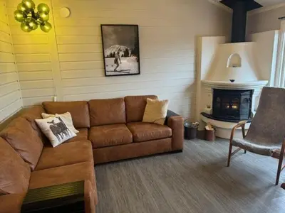 a living room with a couch and a fireplace at Sørlia hytte in Hafjell