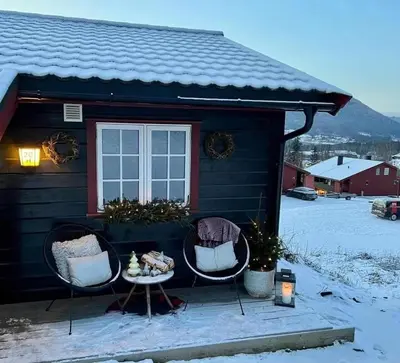 a house with two chairs and a table in the snow at Sørlia hytte in Hafjell