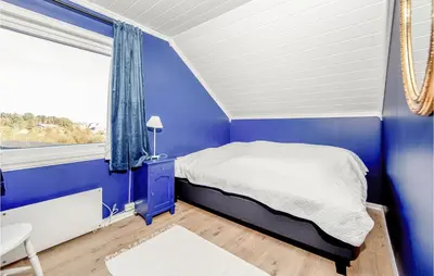 a blue bedroom with a bed and a window at 5 Bedroom Gorgeous Home In Fjørtoft in Fjørtoft