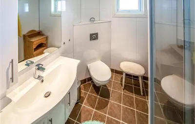 a bathroom with a toilet and a sink and a shower at 5 Bedroom Gorgeous Home In Fjørtoft in Fjørtoft