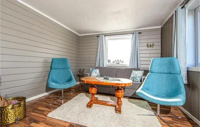 a living room with blue chairs and a table at 5 Bedroom Gorgeous Home In Fjørtoft in Fjørtoft