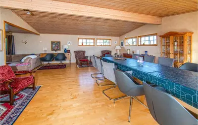 a room with a bar with chairs and a living room at 5 Bedroom Gorgeous Home In Fjørtoft in Fjørtoft
