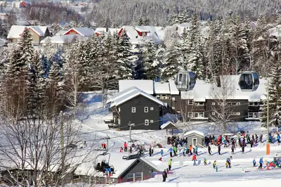 a group of people on a ski resort in the snow at Hafjell Alpinlandsby Pluss in Hafjell