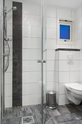 a bathroom with a toilet and a glass shower at Hafjell Alpinlandsby Pluss in Hafjell