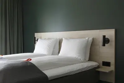 a large bed with white sheets and pillows at Citybox Bergen Danmarksplass in Bergen
