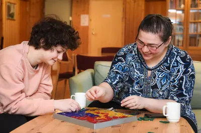 two women sitting at a table playing with a puzzle at Raulandsakademiet in Rauland