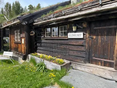 an old wooden building with a sign on it at Raulandsakademiet in Rauland